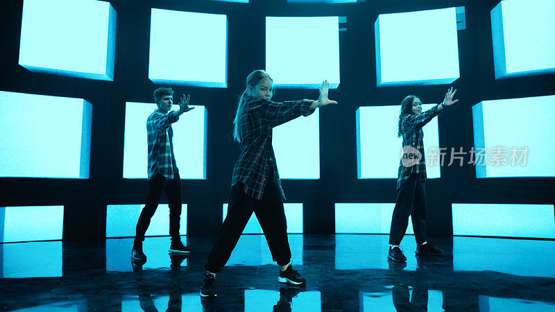 在工作室环境的虚拟制作过程中，三名专业舞蹈家在一个大的Led墙壁屏幕前用VFX动画表演嘻哈舞常规。105 BPM歌曲。